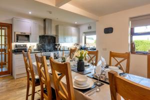 a kitchen and dining room with a table and chairs at Garth Cottage in Gwaynynog