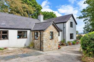 an old stone house with a garage at Garth Cottage in Gwaynynog