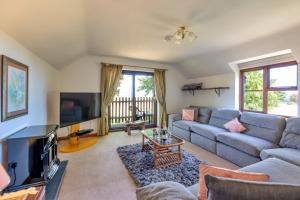 a living room with a couch and a tv at Garth Cottage in Gwaynynog