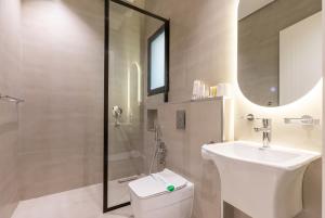 a bathroom with a toilet and a sink and a shower at Amber Hospitality - Blvd in Riyadh +136 photos