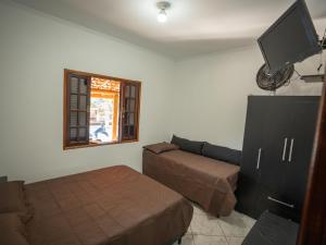 a living room with a couch and a tv at Chácara Pimenta Vermelha in Socorro +72 photos