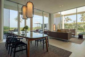 a dining room and living room with a table and chairs at Al Zorah Beach Resort in Ajman 
