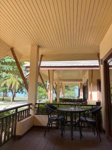 a patio with a table and chairs on a balcony at Chaithalay Khanom Resort in Ban Phang Phrao