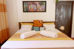 a bed with two pillows on it in a room at Nature Beat villa in Mirissa