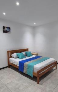 a bed with blue pillows in a bedroom at Superbe Villa 6 personnes avec piscine - Le Sega in Pointe aux Sable