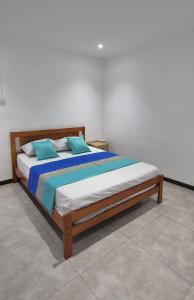 a large bed with blue pillows in a bedroom at Superbe Villa 6 personnes avec piscine - Le Sega in Pointe aux Sable