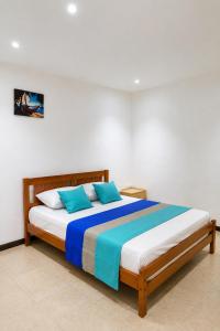 a bed with two blue pillows in a room at Superbe Villa 6 personnes avec piscine - Le Sega in Pointe aux Sable +29 photos
