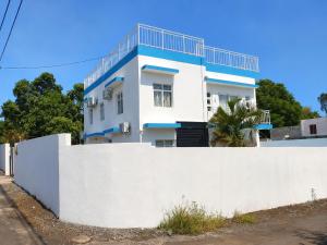 a white house behind a white fence at Superbe Villa 6 personnes avec piscine - Le Sega in Pointe aux Sable