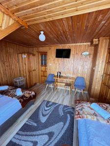 a room with two beds and a table and a television at Wypoczynek u Hajnosa in Białka Tatrzańska