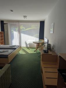 a hotel room with a bed and a desk and a table at Apartment 9, Zentrumsnah mit Pool und Balkon in Bad Essen +16 photos