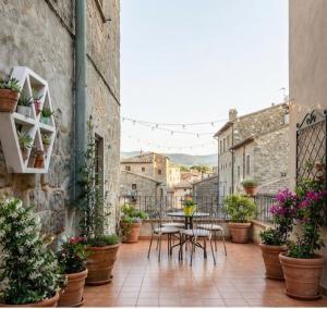 a patio with tables and chairs and potted plants at PALAZZO ALESSANDRINI GUEST HOUSE in Viterbo