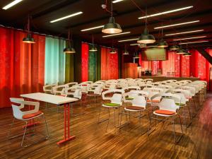a room with tables and chairs and red curtains at 25hours Hotel Zürich West in Zurich +81 photos