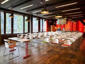a row of tables and chairs in a room at 25hours Hotel Zürich West in Zurich