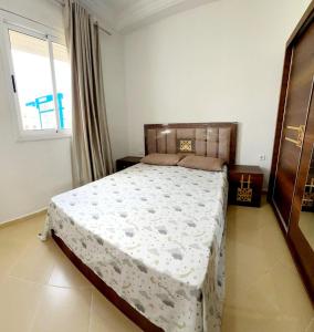 a bedroom with a bed in a room with a window at Appartement À Martil in Martil