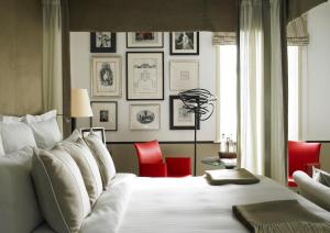 a bedroom with a white bed with red chairs at The Goodwood Hotel in Chichester