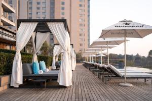 a row of beds on a patio with an umbrella at The Capital on the Park in Johannesburg