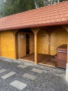 a large wooden gazebo with a red roof at Cabana Magura Mare Belis in Călăţele