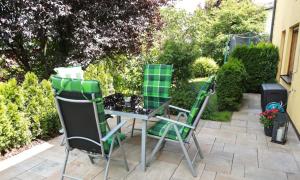 two chairs and a table in a garden at Ferienwohnung Zur Wolfskehln in Viereth-Trunstadt