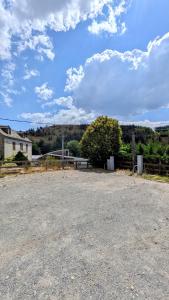 an empty parking lot with a fence and a house at Logis Hôtel restaurant La Remise in Le Bleymard