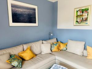 a living room with a white couch with yellow pillows at Gästehaus Peerhus Dönsel - buern in Rehden