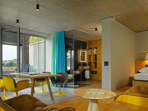 a room with a bed and a table and chairs at 25hours Hotel Langstrasse in Zurich