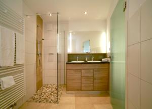 a bathroom with a shower and a sink and a mirror at Schwarzwald Apartments Fürstenberg in Hüfingen +50 photos