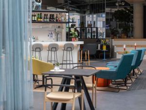 a cafe with chairs and tables and a bar at ibis Styles Delft City Centre in Delft