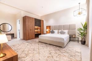 a bedroom with a large bed with a large headboard at Amber Hospitality - Blvd in Riyadh