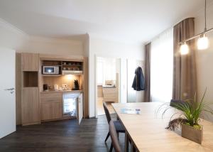 a kitchen and dining room with a table and chairs at Schwarzwald Apartments Fürstenberg in Hüfingen