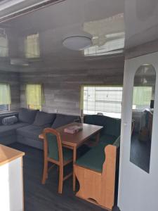 a living room with a couch and a table at Mobilheim Lipno in Černá v Pošumaví