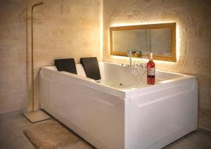 a bath tub with a bottle of wine and two chairs at Aphrodeseum Romantic Suite in Taranto +13 photos