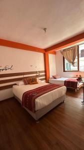 a bedroom with two beds and a window at All sur Cusco in Machu Picchu
