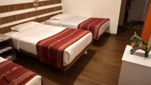 a hotel room with two beds and a toy elephant on a table at All sur Cusco in Machu Picchu