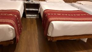 two beds sitting next to each other in a room at All sur Cusco in Machu Picchu