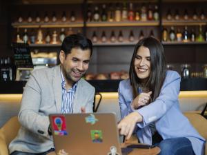 a man and woman looking at a laptop computer at ibis styles Lima San Isidro in Lima