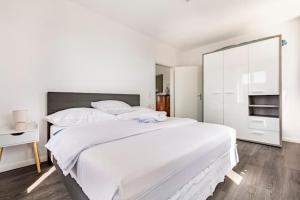 a bedroom with a large white bed and a white cabinet at La belle Époque in Tramelan