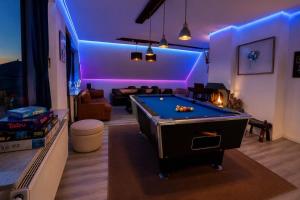a living room with a pool table and purple lighting at Whirlpool Kamin Sauna Herthasee in Eppenrod
