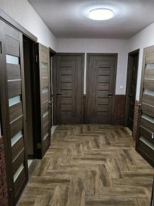 a hallway with wooden doors and wooden floors at Шепіт Річки in Mizhhirya