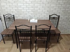 a wooden table with four chairs and a white brick wall at Шепіт Річки in Mizhhirya +34 photos