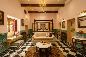 a living room with a couch and a table at WelcomHeritage Mohangarh Fort in Sodākor +41 photos