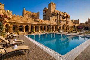 a large building with a swimming pool in front of it at WelcomHeritage Mohangarh Fort in Sodākor