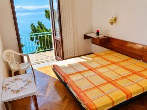 a bedroom with a bed and a large window at Rooms Jakirusa in Brela