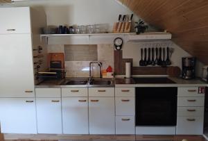 a kitchen with white cabinets and a sink at Ferienwohnung Monteurwohnung Pusteblume in Duderstadt