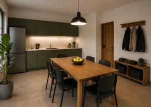 a kitchen with a wooden table with chairs and a dining room at Komfort Apartament Błonie 