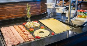 a buffet line with meats and cheese and vegetables at PLAZA Premium Salzburg in Salzburg
