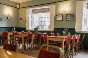 a dining room with tables and chairs and a window at YHA Ilam Hall in Ashbourne