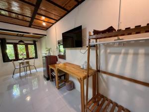 a living room with a wooden table and a tv at Mookboonchu Guesthouse ,Kohmook Trang in Ko Mook