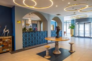a lobby with a table and stools in a building at GINO Seaside Tbilisi, Trademark Collection by Wyndham in Tbilisi City