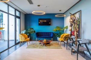 a lobby with blue walls and yellow chairs at GINO Seaside Tbilisi, Trademark Collection by Wyndham in Tbilisi City +56 photos