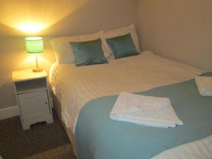 two beds in a room with a lamp on a table at Paramount Hotel in Nottingham